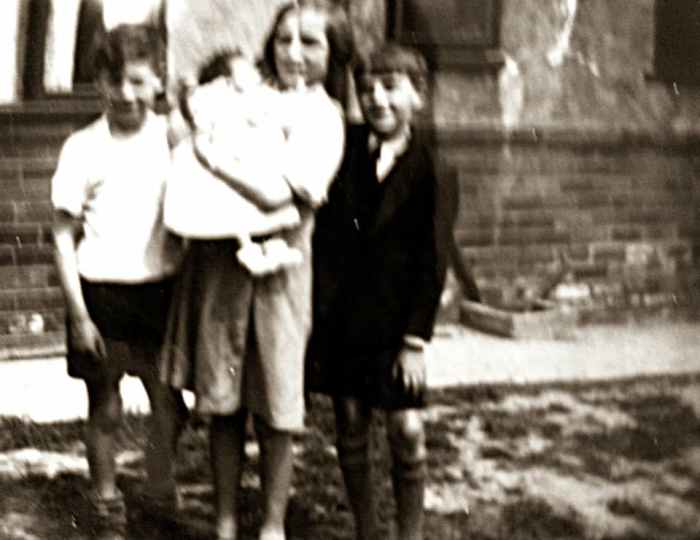 Mum as a child (holding her baby cousin, Shirley Brown) with her little brother Ken on the left and a neighbour's son on the right. They were playing in the street where they grew up in Leeds, Yorkshire.