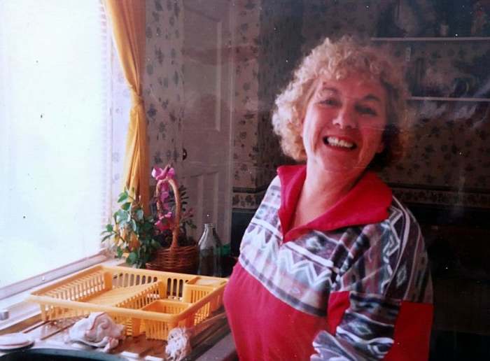 Mum in the late 1990s, washing the dishes while she was dog-sitting for me at my house while I was at work.