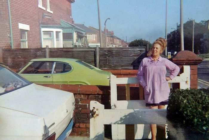 Mum in the'70s taking a breather after work. She is standing in our front garden enjoying the early evening sunshine.
