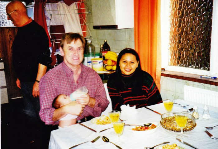My brother Eric, my sister-in-law Liza and my niece Becky when she was a tiny baby, sitting in the kitchen of the house where we grew up, with our dad in the background.