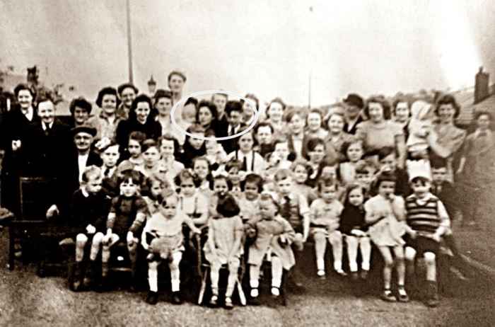 Street party to celebrate victory in Europe in May 1945. Mum is pictured holding a neighbour's toddler and standing next to her brother, Kenneth (circled in the photo, to the left of the centre at the back).