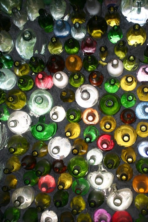 An artist mortars glass bottles to form an unusual building wall