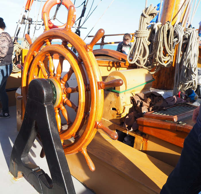 The compass binnacle is just forward of the wheel, so the person steering the ship can easily see it.