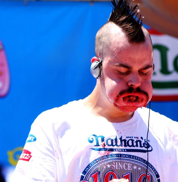 Oh, gross. American competitive eater Patrick "Deep Dish" Bertoletti fills his mouth with hot dogs in the 2010 Nathan's Hot Dog Eating Contest. He placed third in the competition.