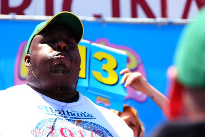 Eric Booker packs in his 14th hot dog in the 2010 Nathan's competitive hot dog eating contest. Despite what you might think, not all competitive eaters are large.