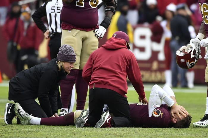 Alex Smith lying in pain after breaking his leg. He spent four weeks in the hospital after surgery with infections. At 34, he is near the end of his career.
