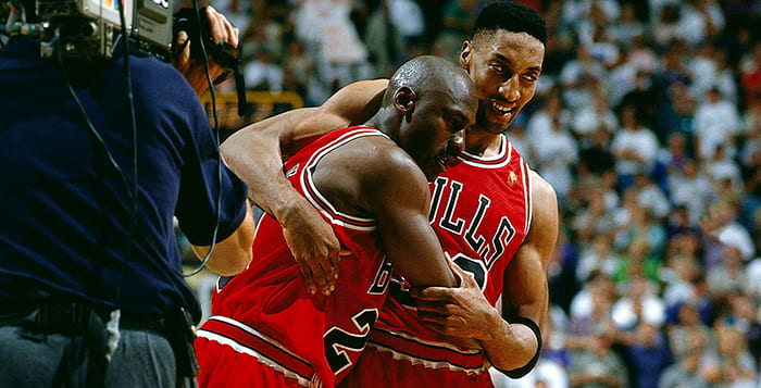 An exhausted Michael Jordan leans on Scottie Pippen after a 38-point outburst despite having flu-like symptoms.