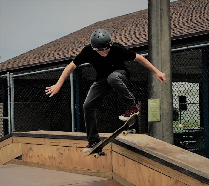 Justin continues to challenge himself on the board, setting an example for young skateboarders at the park.