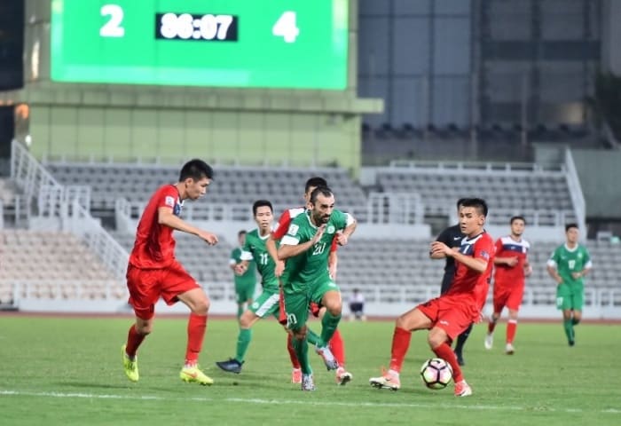 Kyrgyzstan players (red jersey) battle for possession during the second half of a 2019 Asian Cup qualifier at Estádio Campo Desportivo in Macau.