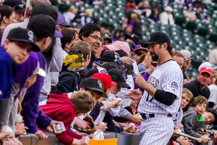 Former Colorado Rockies first baseman Todd Helton signs autographs for fans before a 2013 game. Helton is the greatest Colorado Rockies player of all-time.