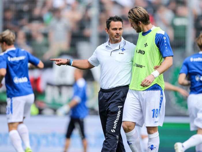 Dirk Schuster consults with defensive midfielder Peter Niemeyer prior to SV Darmstadt 98's match against Hannover 96 on Aug. 15, 2015 at Stadion am Böllenfalltor. This match, a 2-2 draw, was the club's first Bundesliga match in 33 years.