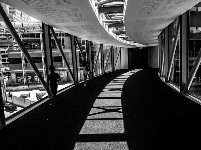 The reflective light is bouncing, casting shadows but still filling the footbridge tunnel with light.