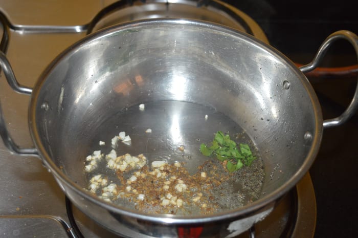 Step three: Heat oil in a deep-bottomed pan. Throw in mustard seeds. Let them crackle. Add chopped garlic, ginger, cumin seeds, and curry leaves. Saute them until you get a nice aroma of the roasted garlic.