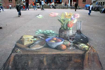 This drawing in Amsterdam is thought to be the first anamorphic still-life ever to be drawn on a pavement. The real-life arrangement was set up in situ.