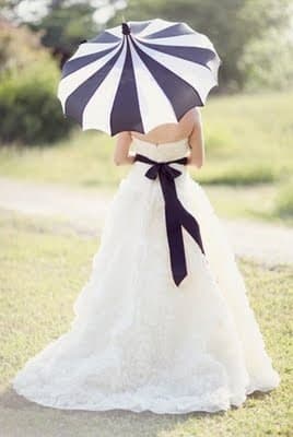 This black and white umbrella is the perfect accessory to match the bride's white gown with a black ribbon.