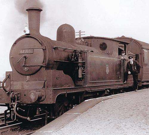 Stockton-on-Tees allocated push-pull fitted 67318 stands at a platform end with station master posing together with the crew on possibly her last working day