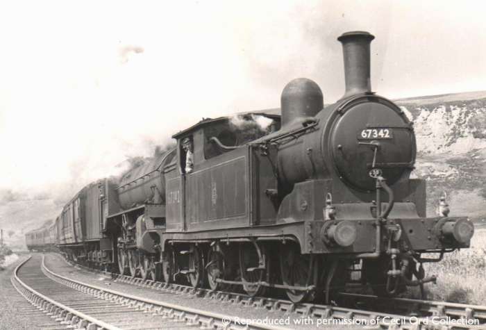 Darlington G5 67342 pilots an unknown Class B1 4-6-0 with a heavy Whitby-bound holiday express (two lamps on the pilot) over Goathland summit - she may have taken a train to Malton and been seconded to this duty to return to her home depot