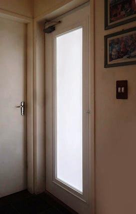 Here is a glass-fitted door that lets light flow from a natural source of light into a dark hallway.