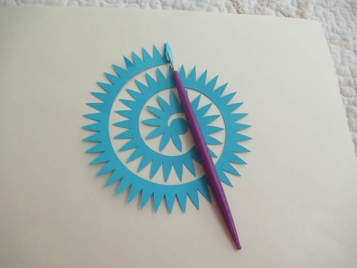 You start at the outer end and roll into the center of the template. The round piece on the inner most part of the tool is used to glue the flower to. It acts as a base