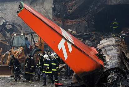 Fiery wreckage of a TAM Airbus after it attempted to land in heavy rain at Congonhas Airport. The plane skidded off the end of the runway across a major roadway and struck a gas station and building, bursting into flames.