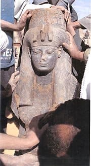 Black granite statue of Queen Tiye, mother of Akhenaton. This statue features a standing Queen Tiye wearing a wig and a cobra-decorated crown.