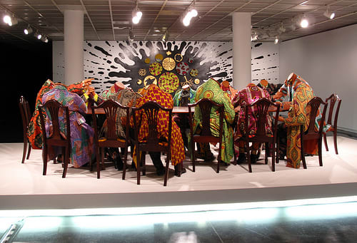 Decapitated African heads, clad in African cloth, bought from Dutch, who took the Batik from Indonesia, and the cloth making technique from Africa, and resold it to Africans