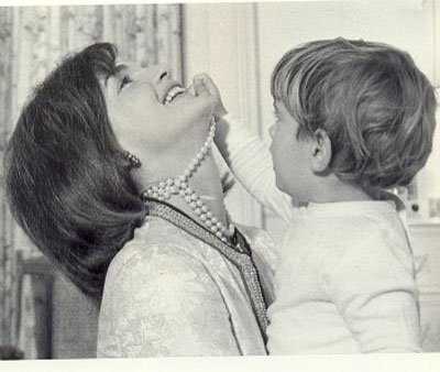 photo of Jackie Kennedy wearing her famous three strand pearl necklace with JFK Jr playing with the necklace