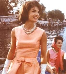 Jackie Kennedy wearing her three strand pearl necklace with her sister Lee in the background