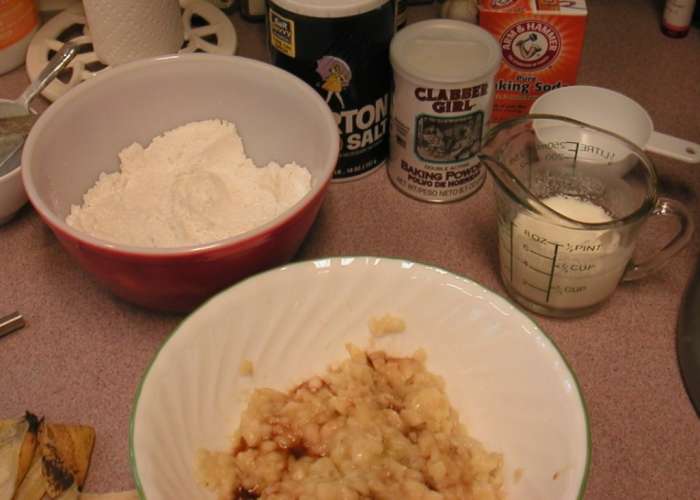 Add the vanilla extract and the sour milk to the bananas. Alternate wet and dry ingredients when adding to the mixing bowl.