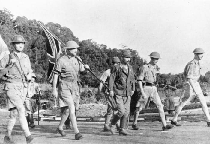Lt. General Arthur Percival (carrying the Union flag) and his party on their way to surrender to the Japanese.