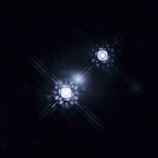 First-ever photo of an accretion disk around a quasar -- times two! The smudge in the middle is a galaxy whose gravitational lens created a magnified double image of the "accretion disc" around this distant black hole.