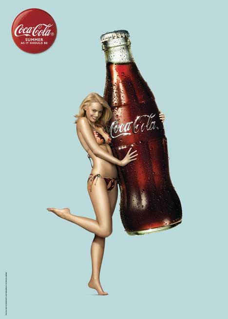 super large Coca Cola bottle and sultry girl scantily clad in a bikini