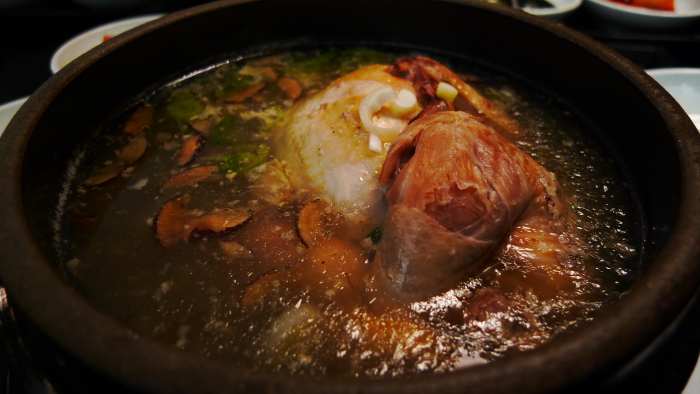 chicken ginseng soup. a whole young chicken is stuffed with rice and boiled in a broth of Korean ginseng, dried seeded jujubes, garlic and ginger.