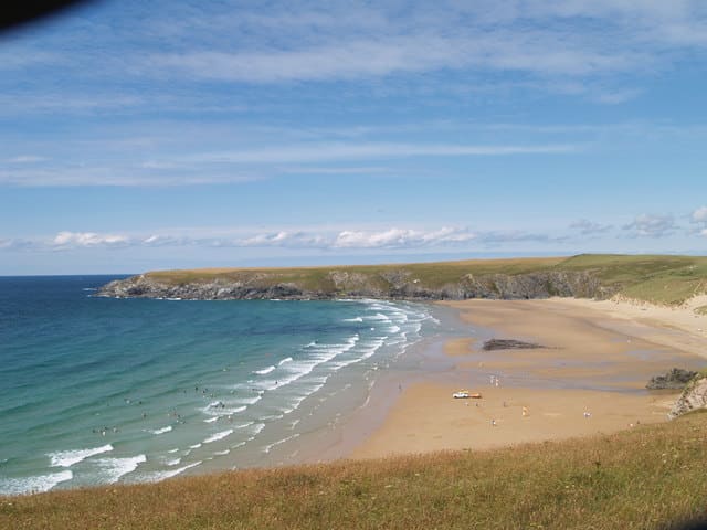 Holy Wells at Holywell Bay: Looking north, the caves are where the sea meets the sand in this photo. Only visit 2 hours either side of high tide.