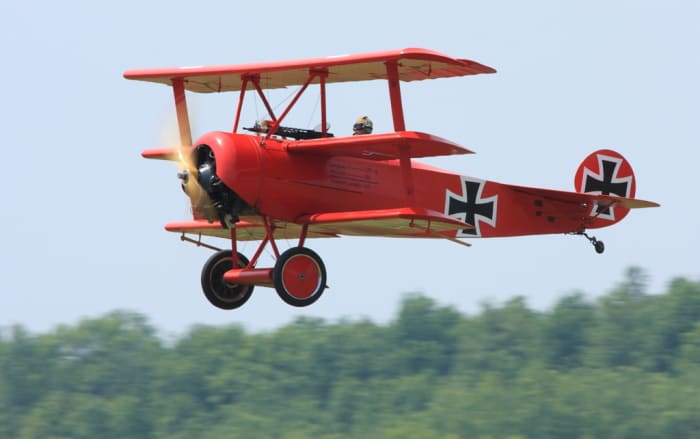 Replica Fokker DR.I Triplane painted in the same colors as the Red Baron's plane, being flown at an air show.