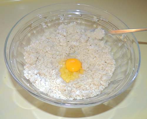 scoop out a divot in the center, and add egg(s) incrementally. You're looking for an unsticky, but not dry texture. Also, try not to work the dough too much as you blend ingredients, as this will make for tough dumplins!