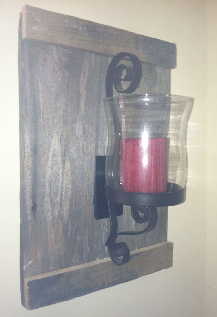 Free barn wood, thrown away, a thirty three cent sconce and and a twenty five cent glass globe together with a candle, a gift form a friend, came together to create this Hurricane lamp wall art for a grand total of fifty eight cents