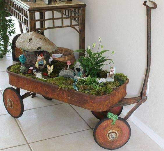 You need to drill holes in the bottom of the wagon if you are using outside where rain can overfill it. Inside, you can control the watering and can skip that step. Look at the use of one taller plant and then low moss for the garden.