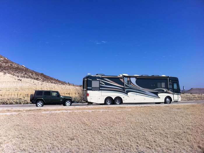 A large motorhome pulling a Jeep tow car "4-down", which is a typical preferred towing configuration of most motorhome owners.