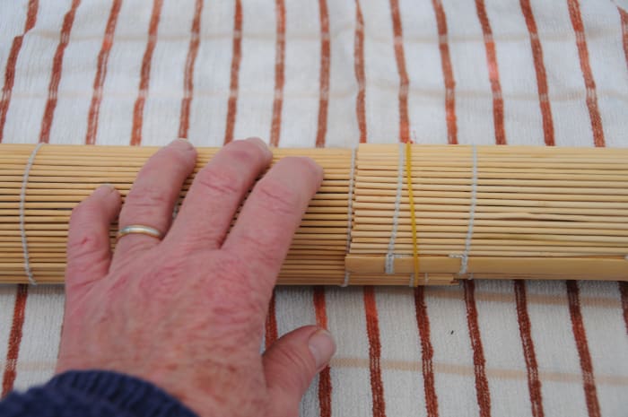 Rolling on a tea towel helps to soak up any additional moisture and makes it easier to roll the sushi mats.
