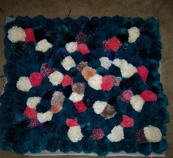 But before I turned the edges underneath and sewed them to hide the backing. Also, clearly I used more blue yarn than anything else, for two reasons: it matches the room it was going to live, and the blue yarn was on sale when I had to buy more.
