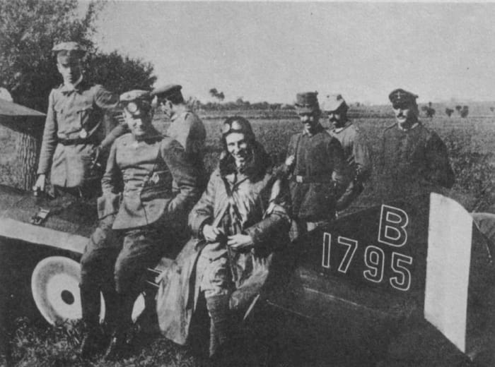 Manfred von Richthofen ("The Red Baron") posing beside Anthony Fokker. Both men are sitting on a crashed Allied plane. Richthofen, without goggles, is on the left.