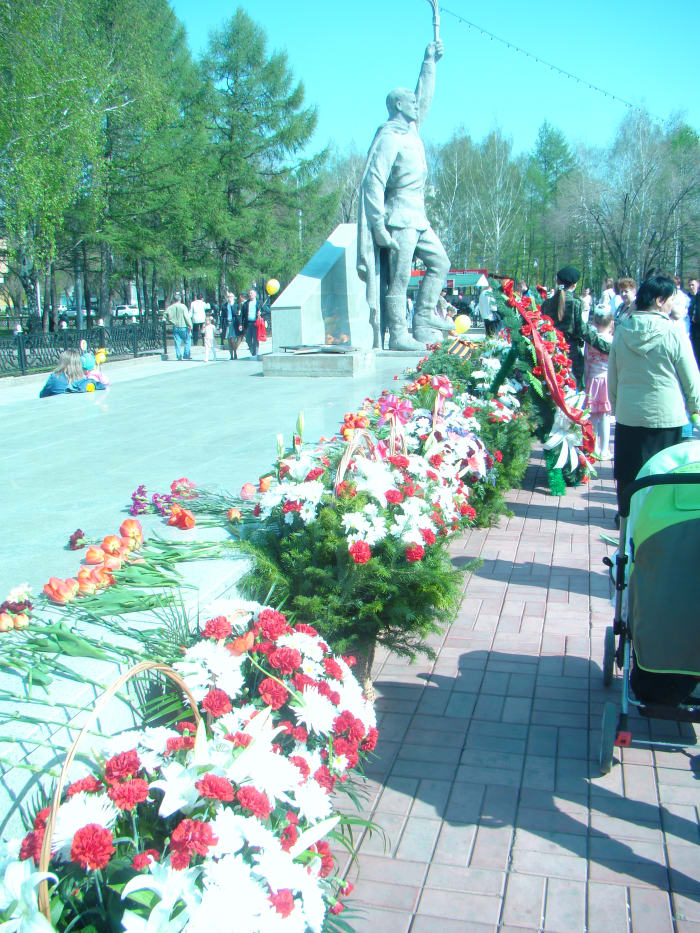 Flowers are laid down by Men , Women and Children during the celebration and holiday of the 9th of May