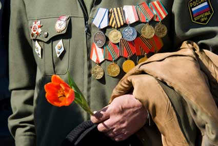 A Russian Wold War II veteran places a poppy on a war memorial site during the Russia celebration of the Patriotic War