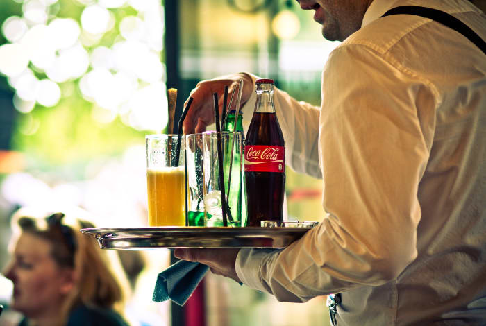 Those who think tips are something extra do not realize the level of training a preparation required to be a good service representative, no matter what the industry. Here, a waiter serves chilled drinks in Paris.