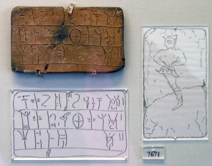Tablet is inscribed in Linear B. The tablet comes from the House of the Oil Merchant. The tablet contains a register of an amount of wool to be dyed.