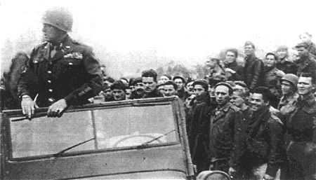 General Patton speaking to the prisoners. Their jubilation quickly turned to anger as they were asked to stay within the compound until the entire area was secure. He told the men, "I need to go kill more Germans."