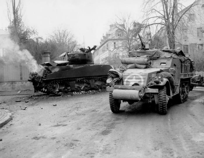April 1945: Help is on the way. A unit of the 14th Armored Division fighting their way through a German town, just west of Hammelburg.