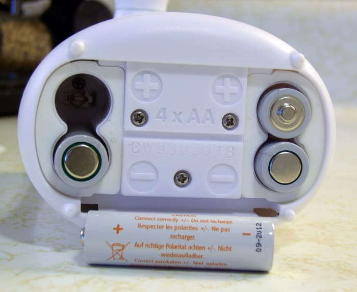 The three visible screws secure the base to the plastic gear box. Each battery compartment has a screw at the bottom. When removed, the gray plastic lining can be detached from the base, exposing the machine's plumbing.