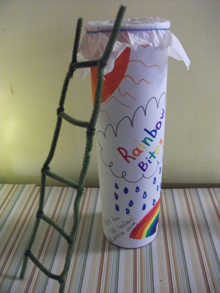The leprechaun is lured to the trap by the promise of real rainbows bites. When he climbs onto the top of the container to grab a rainbow treat, the tissue paper covering the top breaks. The leprechaun is trapped in the Rainbow Bites.